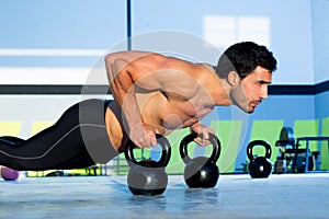 Gym man push-up strength pushup with Kettlebell