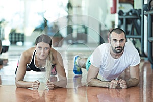 Gym man and woman push-up strength pushup with dumbbell in a fitness workout