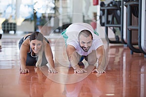 Gym man and woman push-up strength pushup with dumbbell in a fitness workout