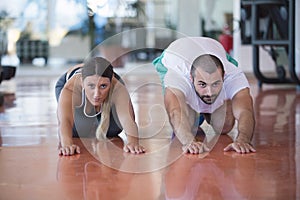 Gym man and woman push-up strength pushup with dumbbell in a fitness workout