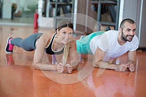 Gym man and woman push-up strength pushup with dumbbell in a workout