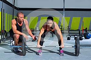 Gym personal trainer man with weight lifting bar woman