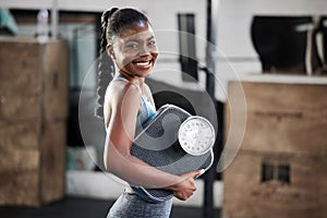 Gym, portrait or happy black woman with scale after body training or fitness workout to lose weight. Wellness, personal