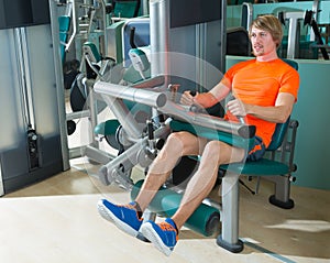 Gym seated leg curl machine exercise blond man