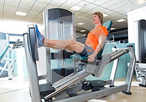 Gym seated leg press machine blond man workout