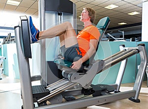 Gym seated leg press machine blond man workout