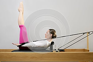 Gym woman pilates stretching sport in reformer bed photo