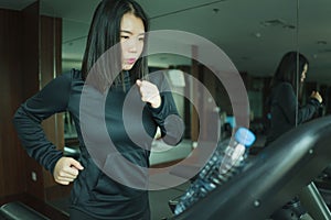 Gym workout portrait of young beautiful and sporty Asian Korean woman running at fitness club jogging in treadmill training in