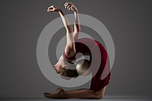 Gymnast girl bending backwards with ball