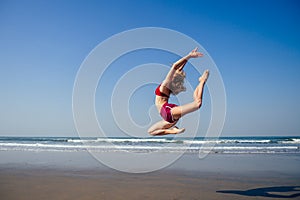 Gymnast girl doing splits grand jete in the air. Beautiful young fit gymnast woman working out, performing art