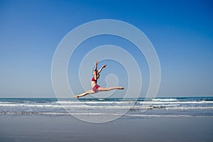 Gymnast girl doing splits grand jete in the air. Beautiful young fit gymnast woman working out, performing art