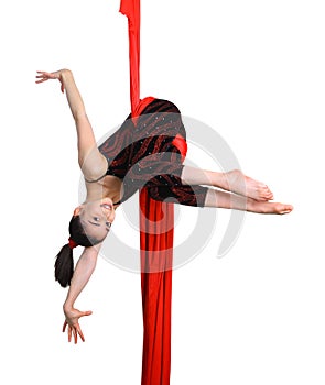 Gymnastic girl exercising on red fabric rope