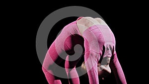 Gymnastics - young woman standing and bending backwards raising her leg up