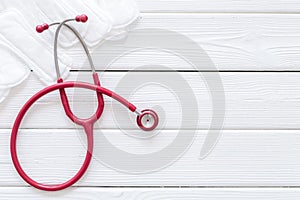 Gynaecologist and woman health concept with stethoscope and tampons on white wooden background top view copy space photo