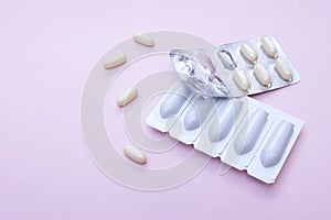 Gynecological medicines for women& x27;s health in form of suppository, capsules on pink background.