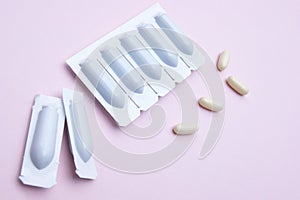 Gynecological medicines for women& x27;s health in form of suppository, capsules on pink background.