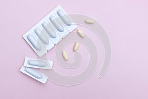 Gynecological medicines for women& x27;s health in form of suppository, capsules on pink background.