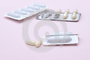 Gynecological medicines for women& x27;s health in form of suppository, capsules on pink background.