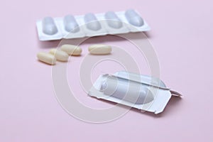 Gynecological medicines for women& x27;s health in form of suppository, capsules on pink background.