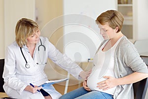 Gynecologist doctor accepts of a pregnant woman. Medical insurance childbearing. Family doctor for gestation. Maternity leave