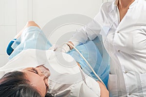 Gynecologist doing ultrasound scanning for pregnant woman