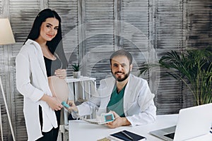 A gynecologist examines a pregnant woman. Fetal doppler heart auscultation