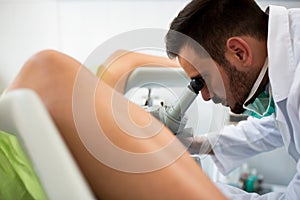 Gynecologist examining a patient with a colposcope