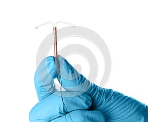 Gynecologist holding copper intrauterine contraceptive device on white background, closeup