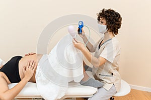 Gynecologist holding a pelvic floor muscle exercise device to prepare for the giving of birth of a woman lying photo