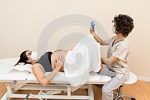 Gynecologist holding a pelvic floor muscle exercise device to prepare for the giving of birth of a woman lying photo