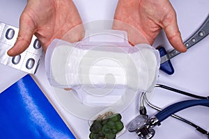 The gynecologist or hygiene doctor demonstrates the opened feminine hygiene pad during the consultation. Concept photo of women us