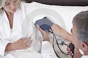 Gynecologist Taking Blood Pressure Of Female Patient photo