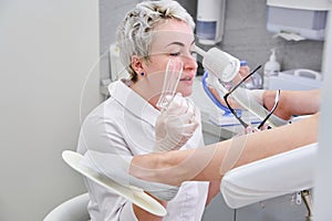 Gynecologist with vaginal speculum in clinic before patient examination