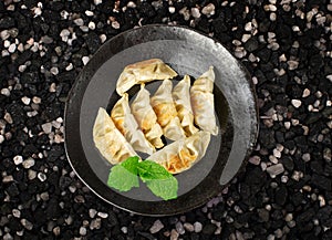 Gyoza Chinese Dumplings Top View, Vegetable Jiaozi, Chicken Momo Pile, Asian Gyoza Portion on Black photo