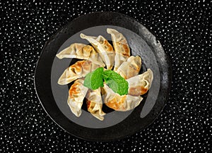 Gyoza Chinese Dumplings Top View, Vegetable Jiaozi, Chicken Momo Pile, Asian Gyoza Portion on Black photo