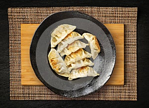 Gyoza Chinese Dumplings Top View, Vegetable Jiaozi, Chicken Momo Pile, Asian Gyoza Portion on Black photo