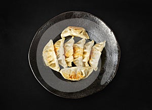 Gyoza Chinese Dumplings Top View, Vegetable Jiaozi, Chicken Momo Pile, Asian Gyoza Portion on Black photo