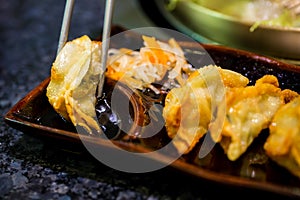 Gyoza on chopsticks. Homemade Asian Vegeterian Potstickers with soy sauce and pork.Japanese Dumplings with chopsticks.
