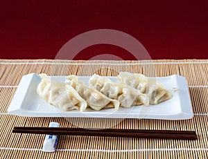 Gyoza or Potstickers on Bamboo Mat with Copy Space