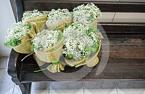 Gypsophila and green leaves bouquets wrapped with burlap sack an