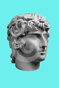 Gypsum copy of ancient famous statue Antinous head isolated on a light green background. Plaster antique sculpture young photo