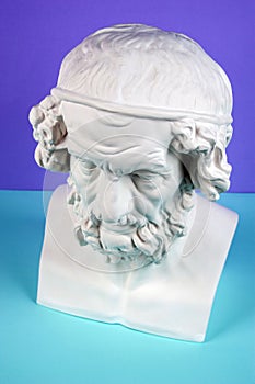 Gypsum copy of ancient statue Homer head on a blue green background. Plaster sculpture man face.
