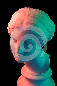 Gypsum copy of ancient statue Venus head isolated on black background. Plaster sculpture woman face. Multi color toned.