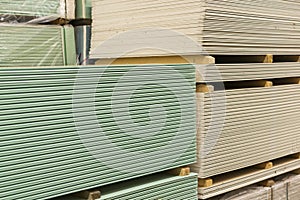 Gypsum plasterboard in the pack. The stack of gypsum board preparing for construction. Pallet with plasterboard in the building