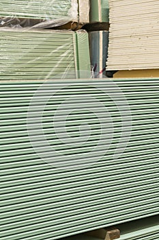 Gypsum plasterboard in the pack. The stack of gypsum board preparing for construction. Pallet with plasterboard in the building