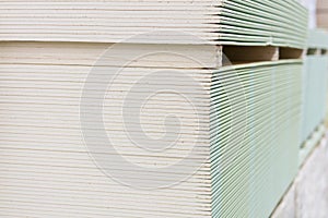 Gypsum plasterboard in the pack. The stack of gypsum board preparing for construction. Pallet with plasterboard in the building