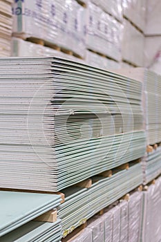 Gypsum plasterboard in the pack. The stack of gypsum board preparing for construction. Pallet with plasterboard in the building