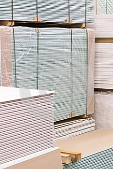 Gypsum plasterboard in the pack. The stack of gypsum board preparing for construction. Pallet with plasterboard in the building