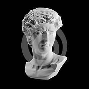 Gypsum statue of David`s head. Michelangelo`s David statue plaster copy isolated on black background. Ancient greek sculpture,