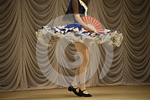 Gypsy dance. A girl in a dress performs on stage. Blue dress in motion